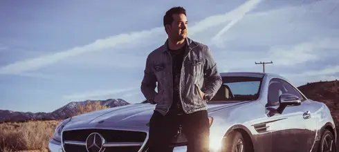 a man standing in front of a mercedes