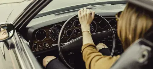 woman driving an old car