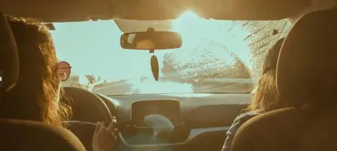 women driving a car into the sunset