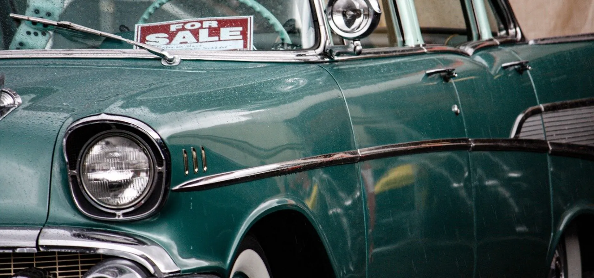 green car with for sale sign