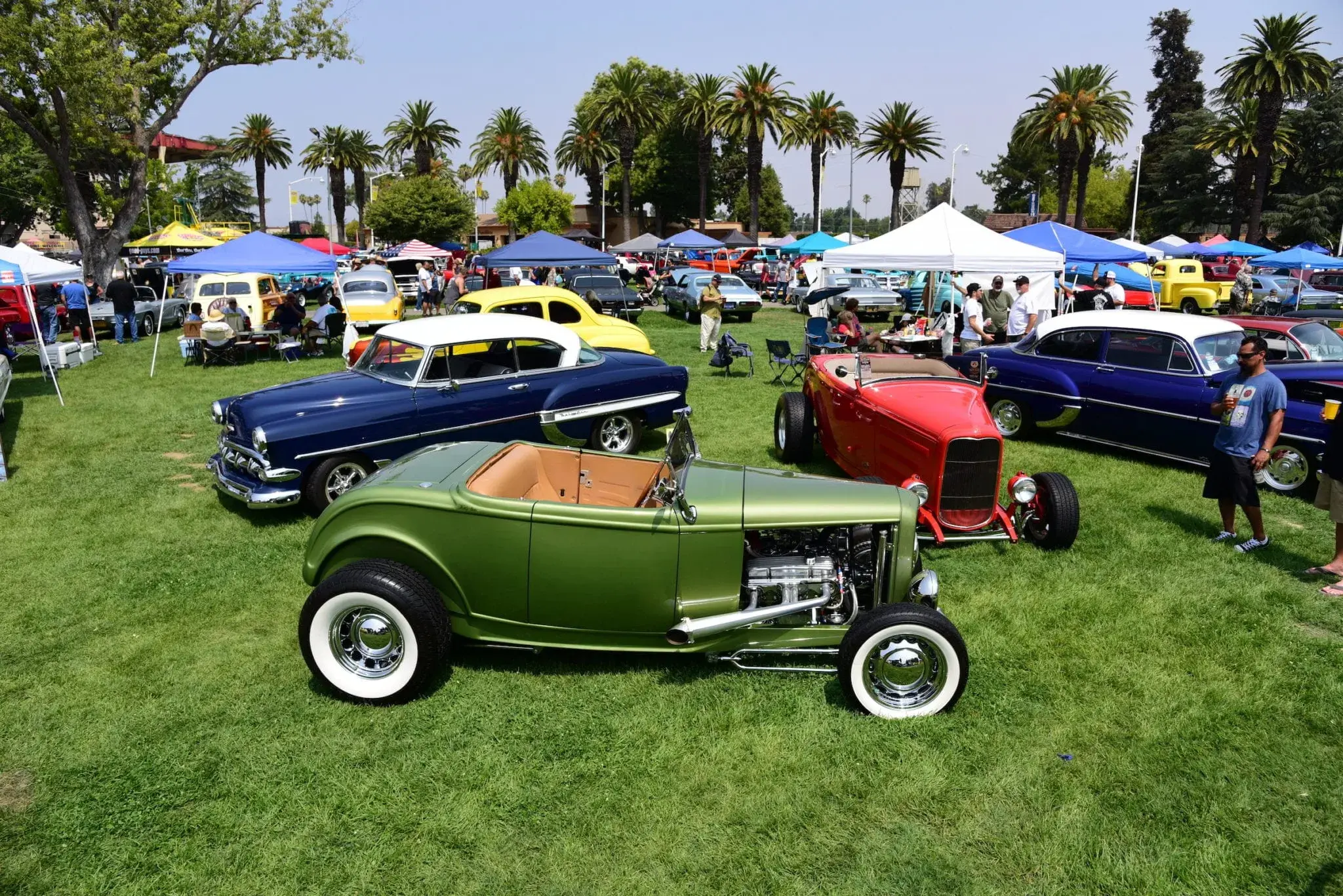 Goodguys Automotive Events cars on grass field with palms in the background