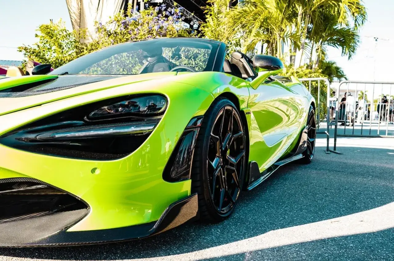 Luxury green car parked in front of some palms Luxury green car parked in front of some palms