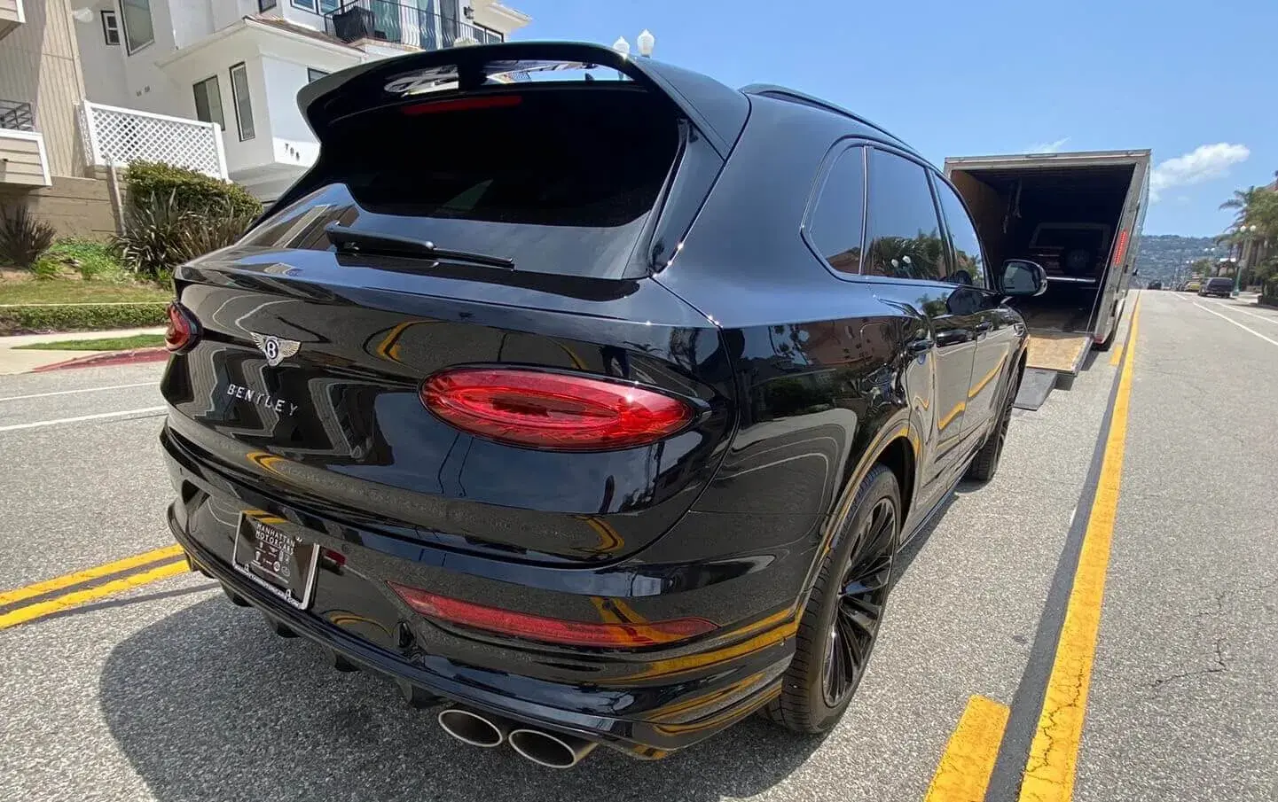 Loading a black Bentley into a closed carrier