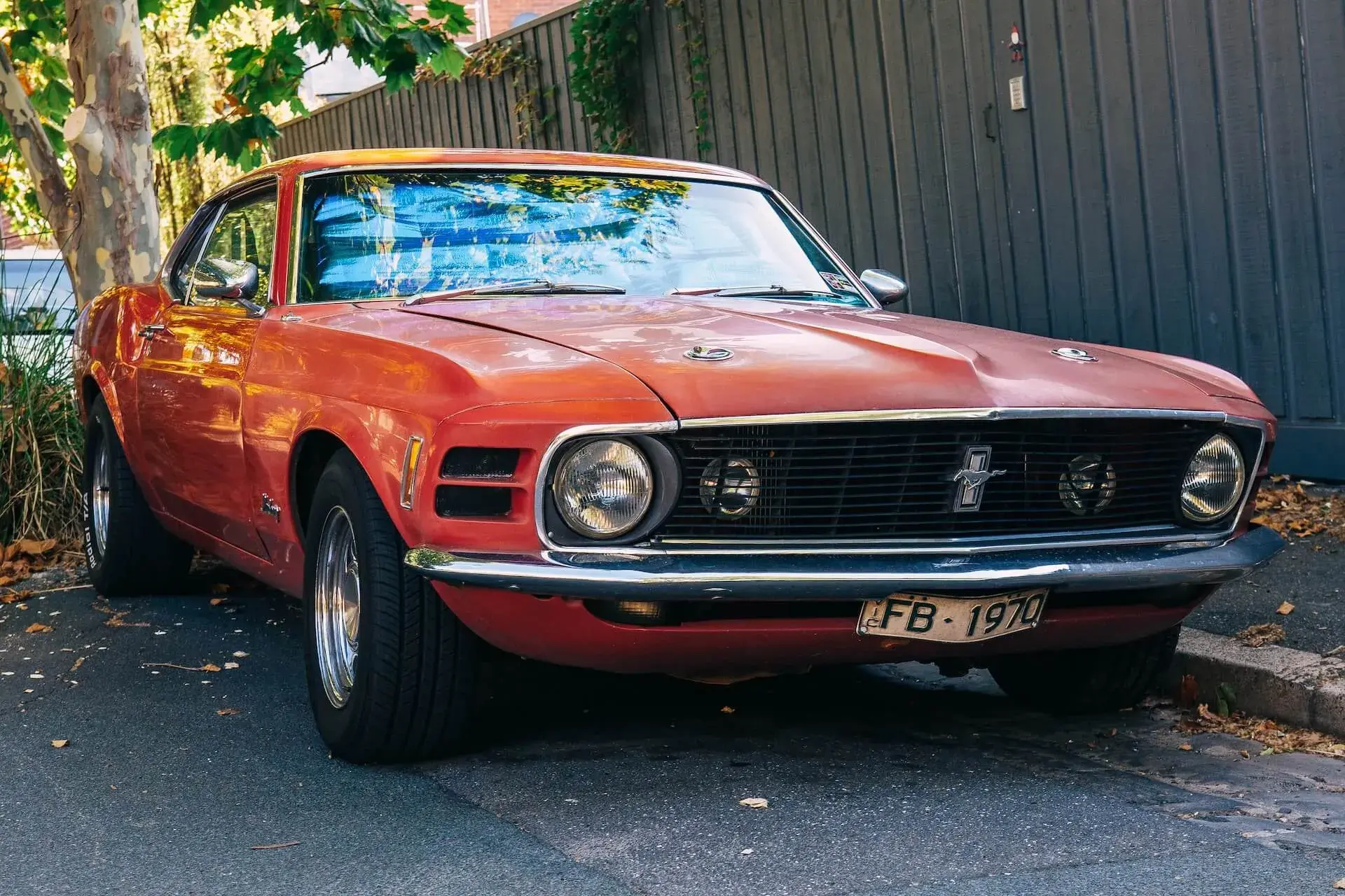 Red Ford Mustang parked next to a fence Red Ford Mustang parked next to a fence