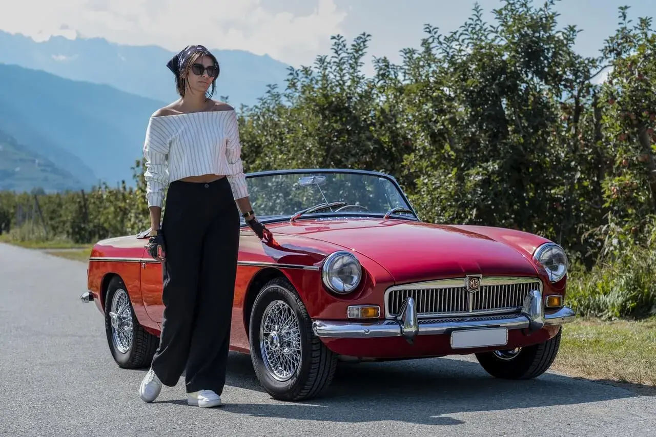 A woman standing next to a red car A woman standing next to a red car