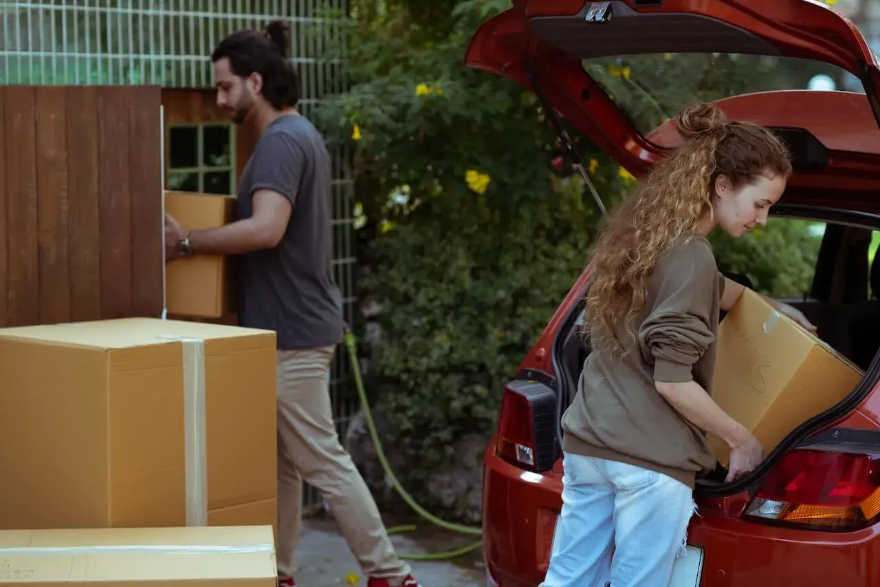 A couple getting carton boxes in the car A couple getting carton boxes in the car