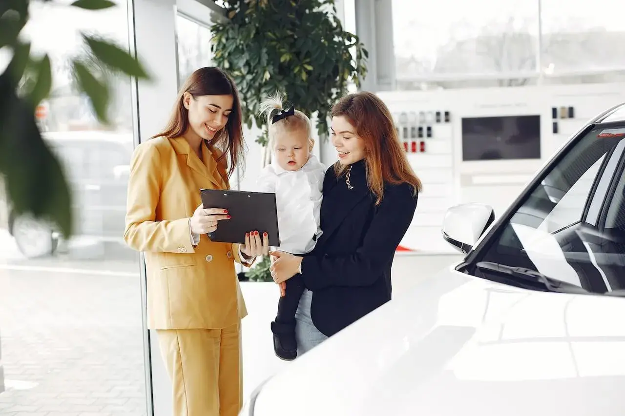 Friendly Car Dealer Showing the Contract to a Customer Friendly Car Dealer Showing the Contract to a Customer