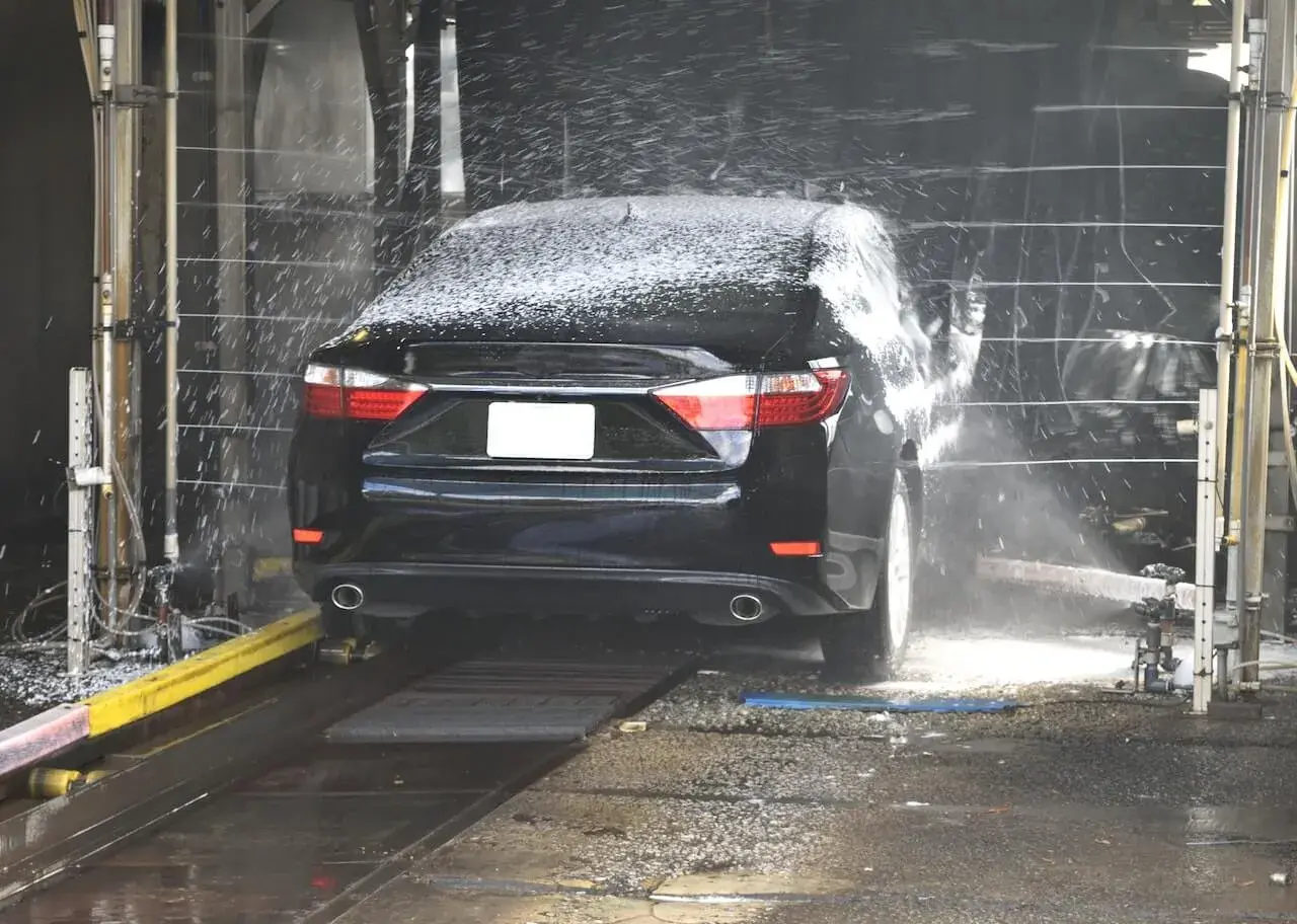 A black sedan at a carwash A black sedan at a carwash