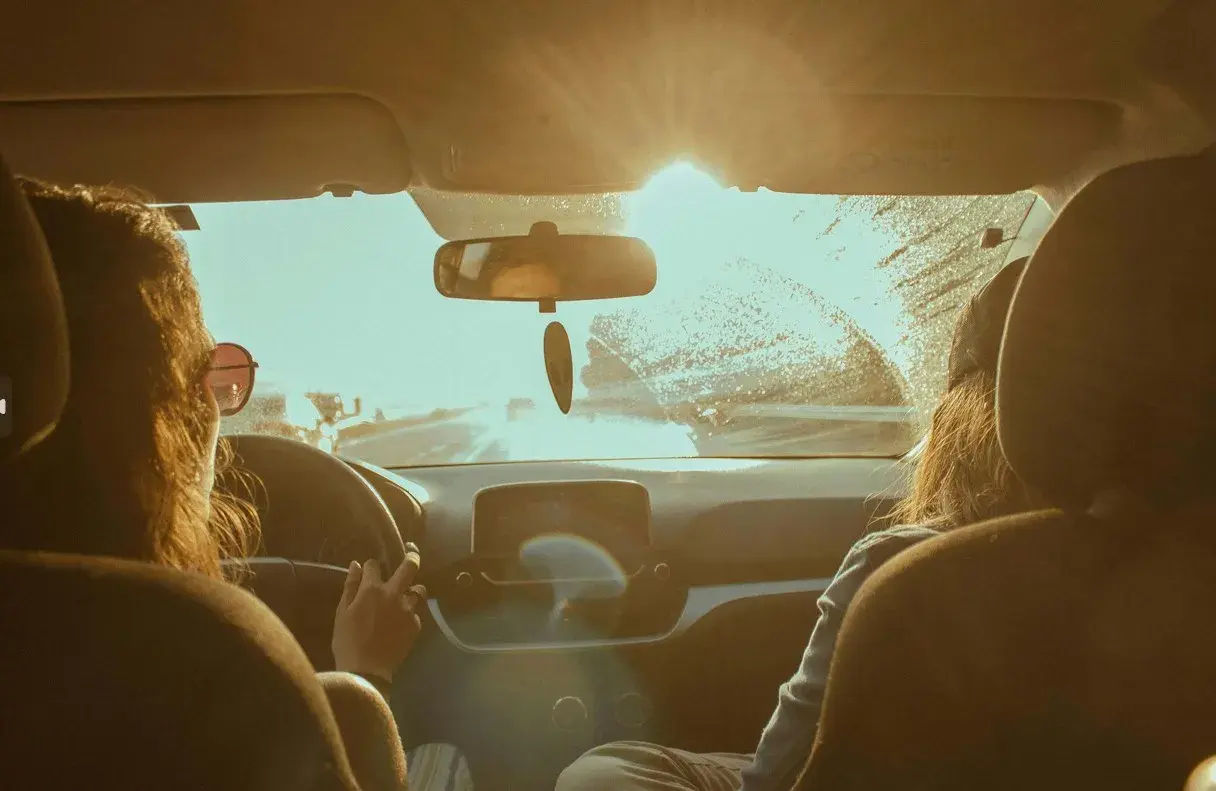 International Women's Day - March 8th women driving a car into the sunset